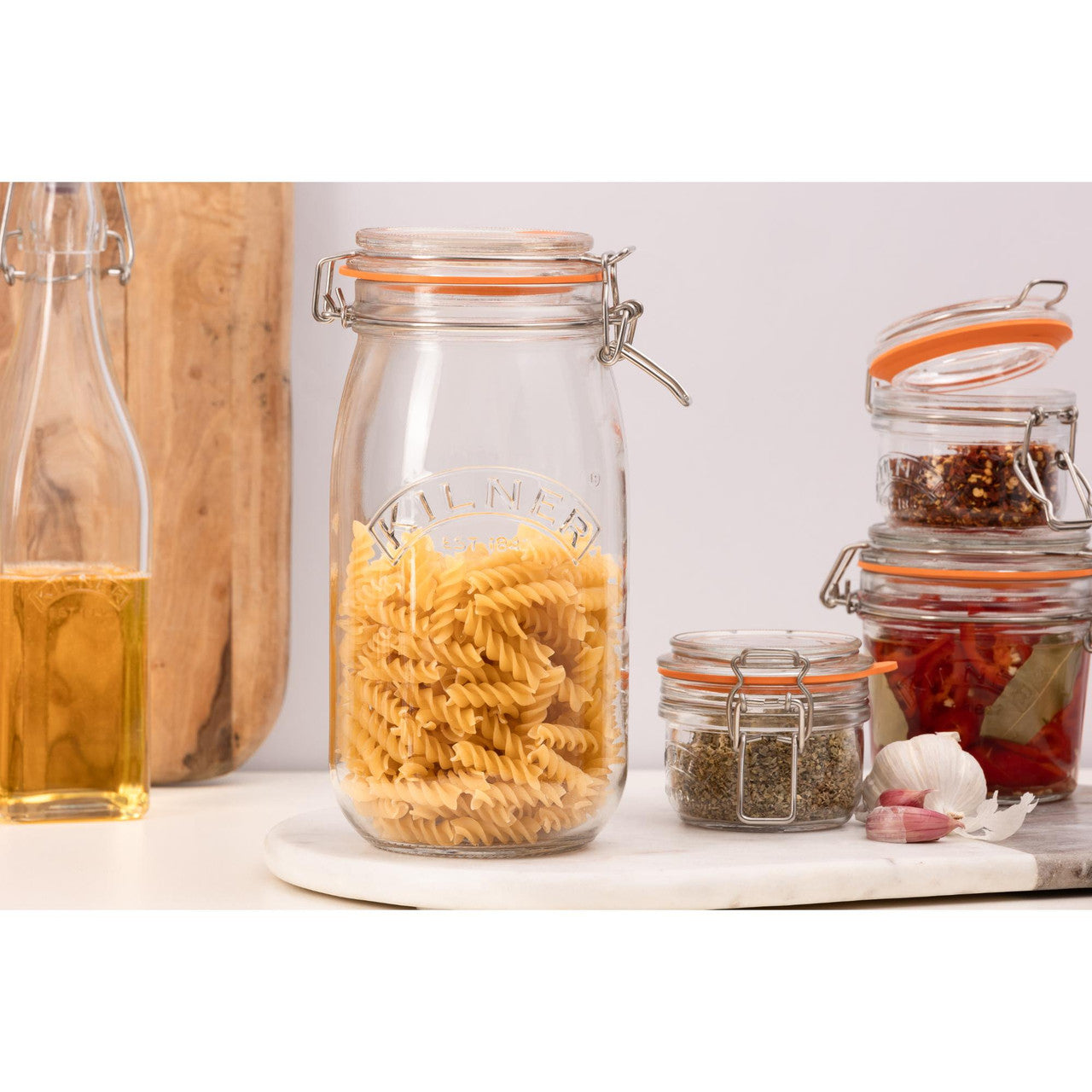 Glass jars with pasta and spices on a kitchen counter