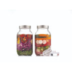 Two glass jars with metal lids containing pickled vegetables on a white background