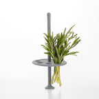 Gray plant stand with a green plant on a white background